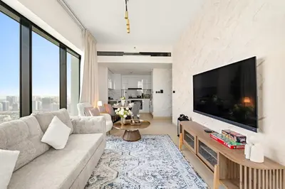 a living room with a large flat screen tv at Stylish 2BR JVC with Pool, Gym Access, and City Skyline Views in Dubai