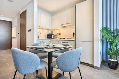 a dining room with a table and chairs and a kitchen at STAY BY LATINEM Luxury 1BR Holiday Home CB 3015 Near Burj Khalifa in Dubai