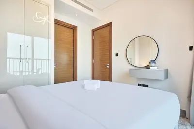 a bedroom with a white bed and a mirror at STAY BY LATINEM Luxury 1BR Holiday Home CB 3015 Near Burj Khalifa in Dubai