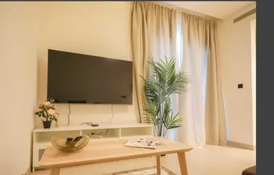 a living room with a tv and a table at Sobha Creek Vistas Reserve, Sobha Hartland, Dubai in Dubai