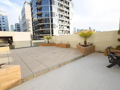 a rooftop patio with benches and a building at Sobha Creek Vistas Reserve, Sobha Hartland, Dubai in Dubai