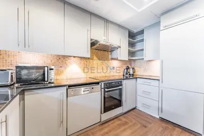 a kitchen with white cabinets and stainless steel appliances at Apartment near Burj Khalifa and Dubai Mall, Central Location, Minutes to Dubai Marina and Palm Jumeirah - 8 BLVD Walk, Downtown Dubai by Deluxe Holiday Homes in Dubai