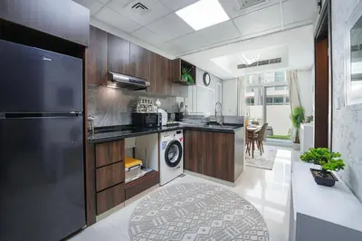 a kitchen with a black refrigerator and a dishwasher at EasyGo Spacious 3BR with Garden in DAMAC Hills 2 in ‘Ūd al Bayḑāʼ