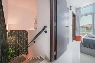 a hallway of a house with a staircase and a window at EasyGo Spacious 3BR with Garden in DAMAC Hills 2 in ‘Ūd al Bayḑāʼ