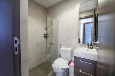 a bathroom with a toilet and a shower and a sink at EasyGo Spacious 3BR with Garden in DAMAC Hills 2 in ‘Ūd al Bayḑāʼ