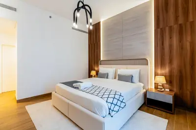 a bedroom with a large white bed and wooden walls at Stylish Apartment in La Mer Dubai in Dubai