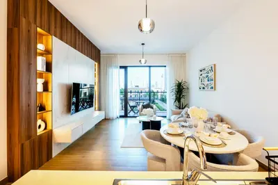 a kitchen and living room with a table and chairs at Stylish Apartment in La Mer Dubai in Dubai