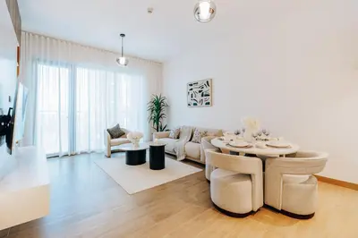 a living room with a couch and a table at Stylish Apartment in La Mer Dubai in Dubai