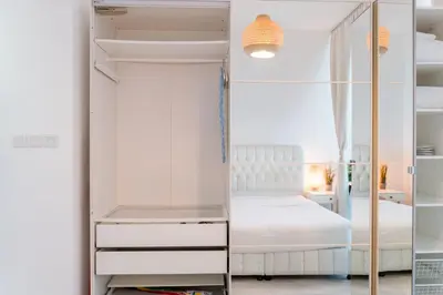 a bedroom with a white bed and a mirror at Scent of the Palms by Lagom in Dubai