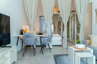 a living room with a table and two chairs at Scent of the Palms by Lagom in Dubai