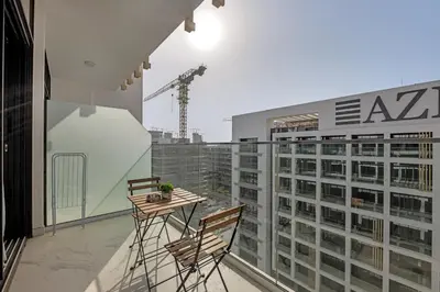 a balcony with two chairs and a table on a building at Chic Dubai Retreat at Azizi Riviera 65 in Dubai