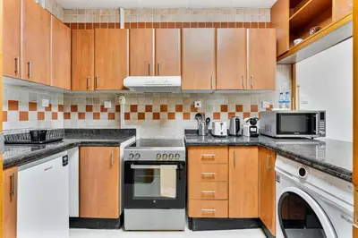 a kitchen with a stove and a microwave at Retro 1BR APT in Marina Near JBR Beach & Mall in Dubai