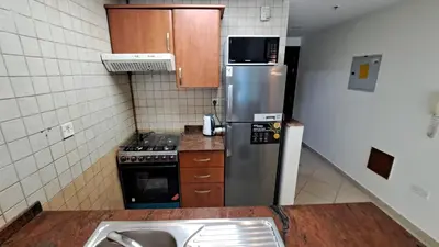 a kitchen with a stainless steel refrigerator and a stove at DRUVYA HOLIDAY HOMES, Marina Diamond 1, Close to Sobha Realty Metro 3 min walkable in Dubai