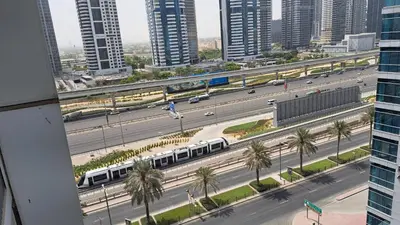 a train on a highway in a city with buildings at DRUVYA HOLIDAY HOMES, Marina Diamond 1, Close to Sobha Realty Metro 3 min walkable in Dubai