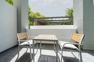 a table and two chairs on a balcony at Luxury JVC 1BR plus Maids Room Escape with Terrace in Dubai