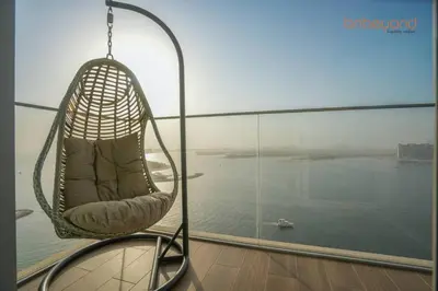 a hanging chair in a room with a view of the water at Exclusive Home with Private Beach in Dubai