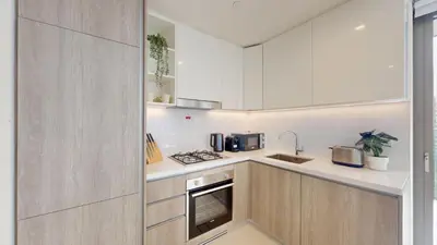 a kitchen with white cabinets and a stove at Vacationer l Urban Luxe 1 Bedroom l with Marina Views in Dubai