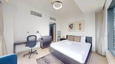 a bedroom with a bed and a desk and a chair at Vacationer l Bright 1 Bedroom l near Marina Promenade in Dubai