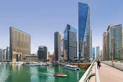 a bridge over a river with boats in a city at Vacationer l Bright 1 Bedroom l near Marina Promenade in Dubai