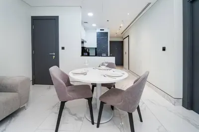 a dining room with a white table and chairs at Contemporary Business Bay 1-Bed with City Views in Dubai
