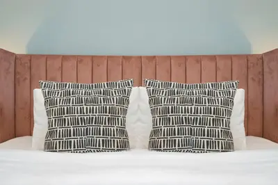 two pillows on a bed with a headboard at Contemporary Business Bay 1-Bed with City Views in Dubai