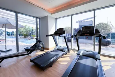 a gym with two treadmills in a room with windows at Contemporary Business Bay 1-Bed with City Views in Dubai