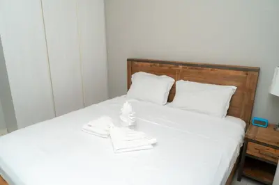 a bed with white sheets and white shoes on it at Stylish 1 BHK in Damac Zada Tower, Business Bay in Dubai