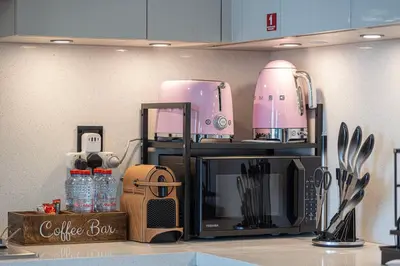 a kitchen counter with a coffee maker on top of a microwave at Moon Stays - Opulent 2BR Stay - Sobha Hartland in Dubai