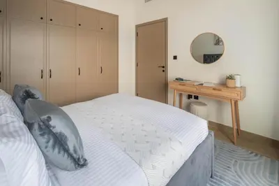 a bedroom with a bed and a desk and a mirror at Frank Porter - Santorini 1, Damac Lagoons in Dubai