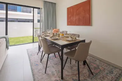 a dining room with a table and chairs at Frank Porter - Santorini 1, Damac Lagoons in Dubai