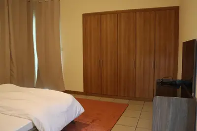 a bedroom with a bed and wooden cabinets at Spacious 1 BR in Sulafa Tower in Dubai