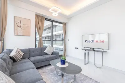 a living room with a couch and a tv at Elegant 2BR Apartment Private Pool by Czechin in Dubai