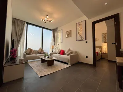 a living room with two couches and a table at The Crest Sobha Hartland in Dubai