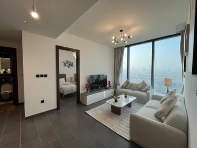 a living room with a couch and a tv at The Crest Sobha Hartland in Dubai