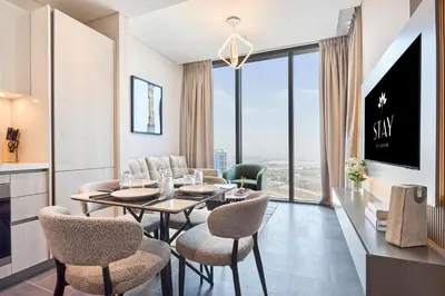 a dining room with a table and chairs and a large window at STAY BY LATINEM Luxury 1BR Holiday Home CB1508 Near Burj Khalifa in Dubai