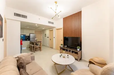 a living room with a couch and a table at Cosy 2 Bed Apartment in Al Jaddaf in Dubai