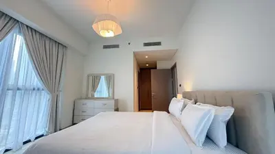 a bedroom with a large bed with white sheets and pillows at Premium 2bed Apartment In Downtown Act1 Tower in Dubai
