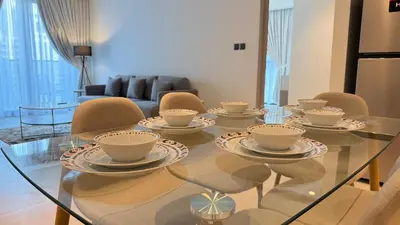a glass table with cups and chairs in a living room at Premium 2bed Apartment In Downtown Act1 Tower in Dubai
