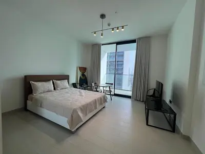 a bedroom with a bed and a table and a television at Binghatti Lavender in Dubai