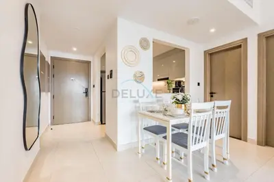 a kitchen and dining room with a white table and chairs at Trendy 1BR with a Glimpse of Burj Khalifa, Near Zabeel Stadium, Minutes Drive to Dubai Frame, Binghatti Creek, Al Jaddaf by Deluxe Holiday Homes in Dubai