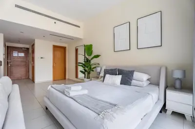 a bedroom with a large white bed with two pictures on the wall at GuestReady - Prime Location Stay | Business Bay in Dubai