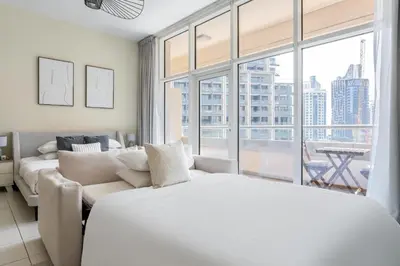 a bedroom with a bed and a couch and a large window at GuestReady - Prime Location Stay | Business Bay in Dubai