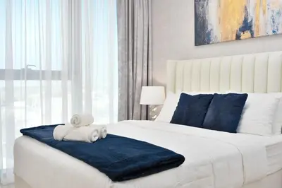 a bedroom with a white bed with a teddy bear on it at Executive 2-Bedroom Apartment in Downtown views 2 with access to Dubai mall in Dubai