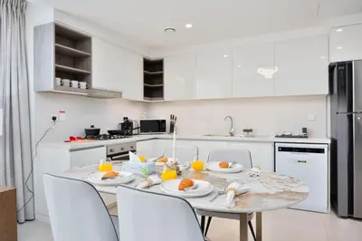 a white kitchen with a table with food on it at Executive 2-Bedroom Apartment in Downtown views 2 with access to Dubai mall in Dubai