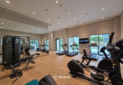 a gym with treadmills and elliptical machines at Waterfront 1BR Apartment in Creek Harbour near Downtown in Dubai