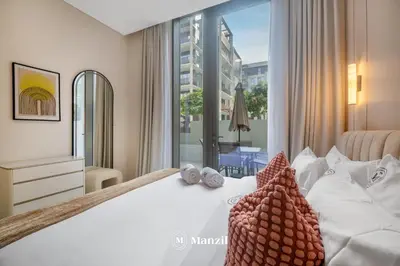 a bedroom with a white bed with a large window at Waterfront 1BR Apartment in Creek Harbour near Downtown in Dubai