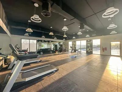 a gym with treadmills and ellipticals in a room at FIRST CLASS VILLA Hidden Luxury Gem in Dubai