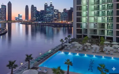 a swimming pool with a city skyline in the background at Spacious 1BR with Balcony and Pool Access in Dubai