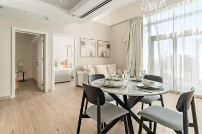 a dining room with a table and chairs at FIRST CLASS 2BR Luxe & Lively Living in Dubai