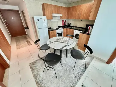 a kitchen with a table and chairs and a refrigerator at Marina Walk View Luxury 1BR close to JBR beach! in Dubai